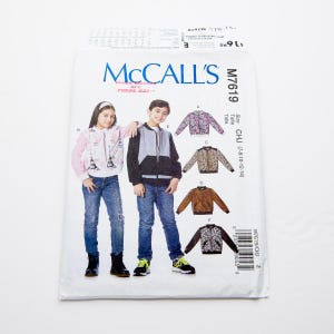 May include: McCall's sewing pattern for children's jackets, pattern number M7619, sizes 7-8, 10, 12, and 14. The pattern includes five different jacket styles, including a bomber jacket, a zip-up jacket, and a fleece jacket.