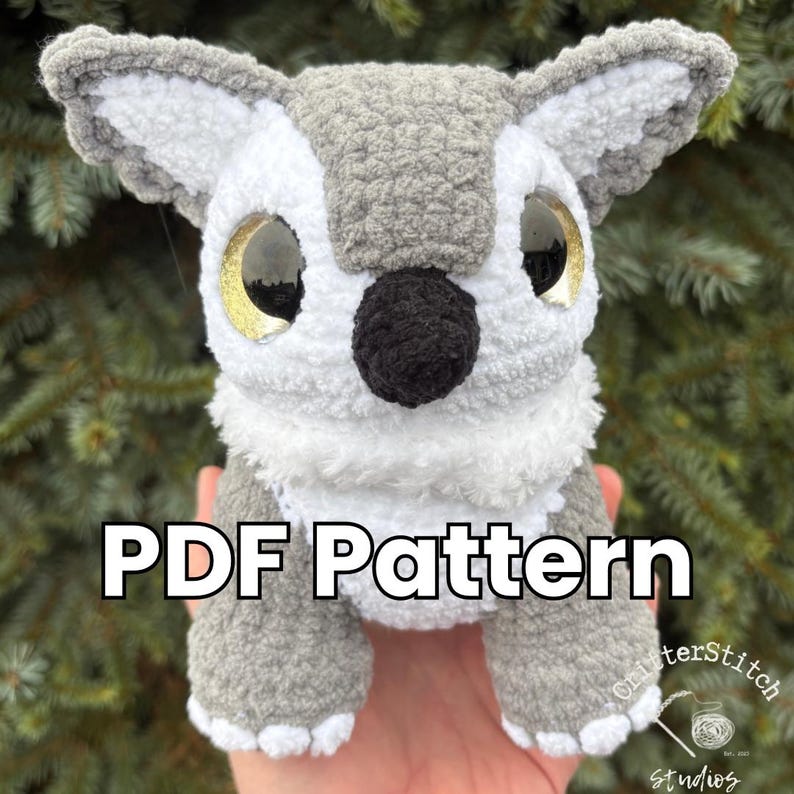 Puede incluir: Un b&uacute;ho de ganchillo hecho a mano con grandes ojos dorados, una nariz negra y pelaje gris y blanco. El texto "PDF Pattern" est&aacute; visible. Es un juguete suave y de peluche.
