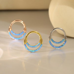 May include: Three hoop earrings with a double row of blue opal stones. The hoops are made of gold, rose gold, and silver.