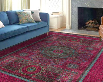 May include: A large, rectangular area rug with a vibrant, ornate design. The rug features a deep magenta field with a central medallion and border in teal, green, and black. The rug is placed in a living room setting.