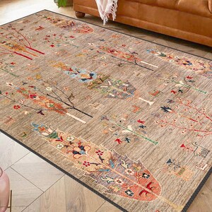 Puede incluir: Una alfombra beige con un patrón repetitivo de árboles y flores estilizados en tonos de rojo, azul, verde y marrón.