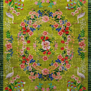 Pode incluir: Um tapete retangular com um design floral vibrante sobre um fundo verde. O tapete apresenta uma coroa floral central com flores vermelhas, rosa e azuis, rodeada por arranjos florais adicionais e p&aacute;ssaros brancos. A borda &eacute; listrada em verde escuro.