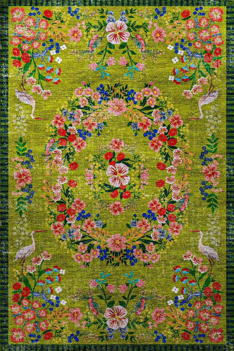 Pode incluir: Um tapete retangular com um design floral vibrante sobre um fundo verde. O tapete apresenta uma coroa floral central com flores vermelhas, rosa e azuis, rodeada por arranjos florais adicionais e p&aacute;ssaros brancos. A borda &eacute; listrada em verde escuro.