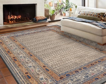 May include: A beige area rug with a patterned border in shades of blue, orange, and brown. The rug has a subtle geometric pattern in the center.