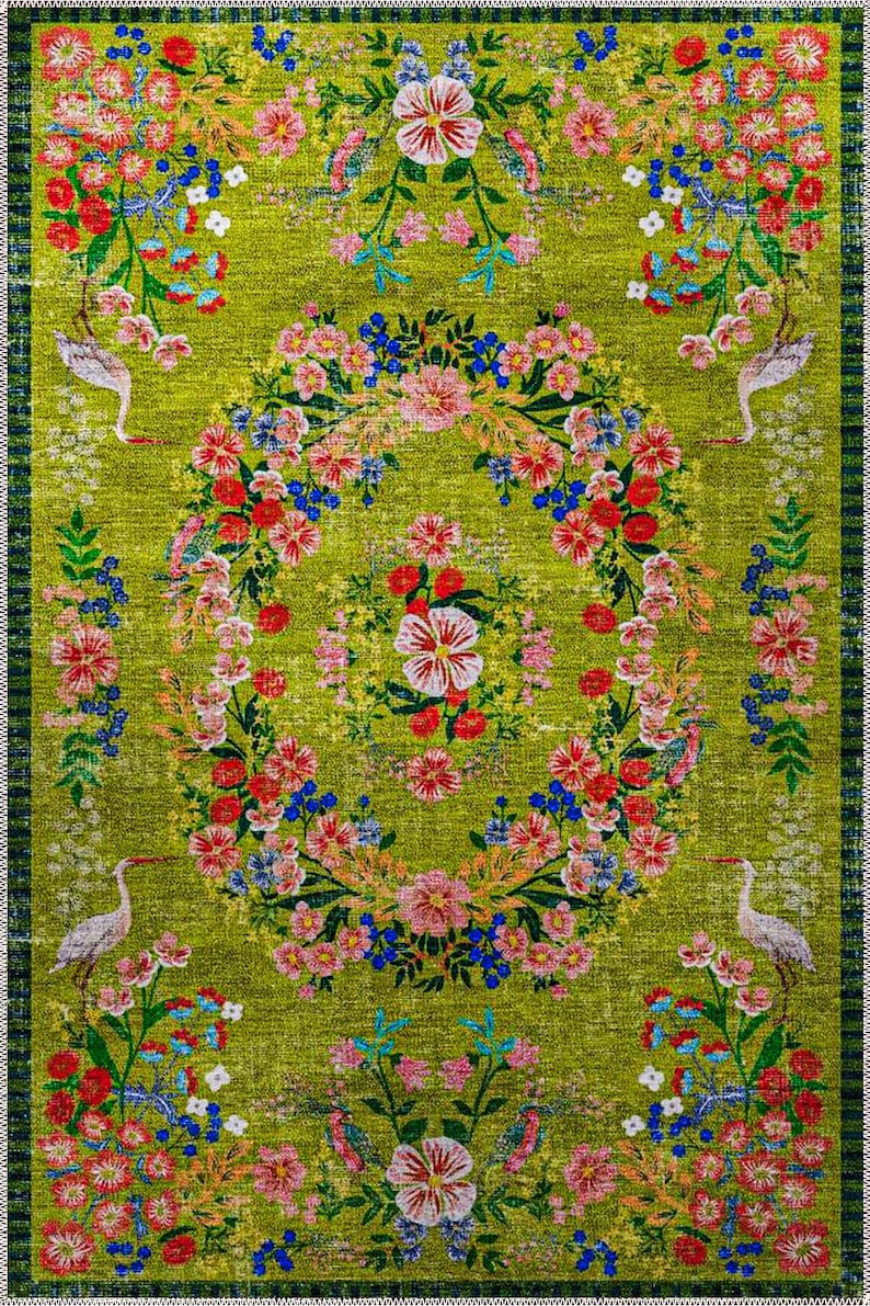 Pode incluir: Um tapete retangular com um design floral vibrante sobre um fundo verde. O tapete apresenta uma coroa floral central e bordas florais, com p&aacute;ssaros brancos intercalados. A paleta de cores inclui flores vermelhas, rosa, azuis e brancas.