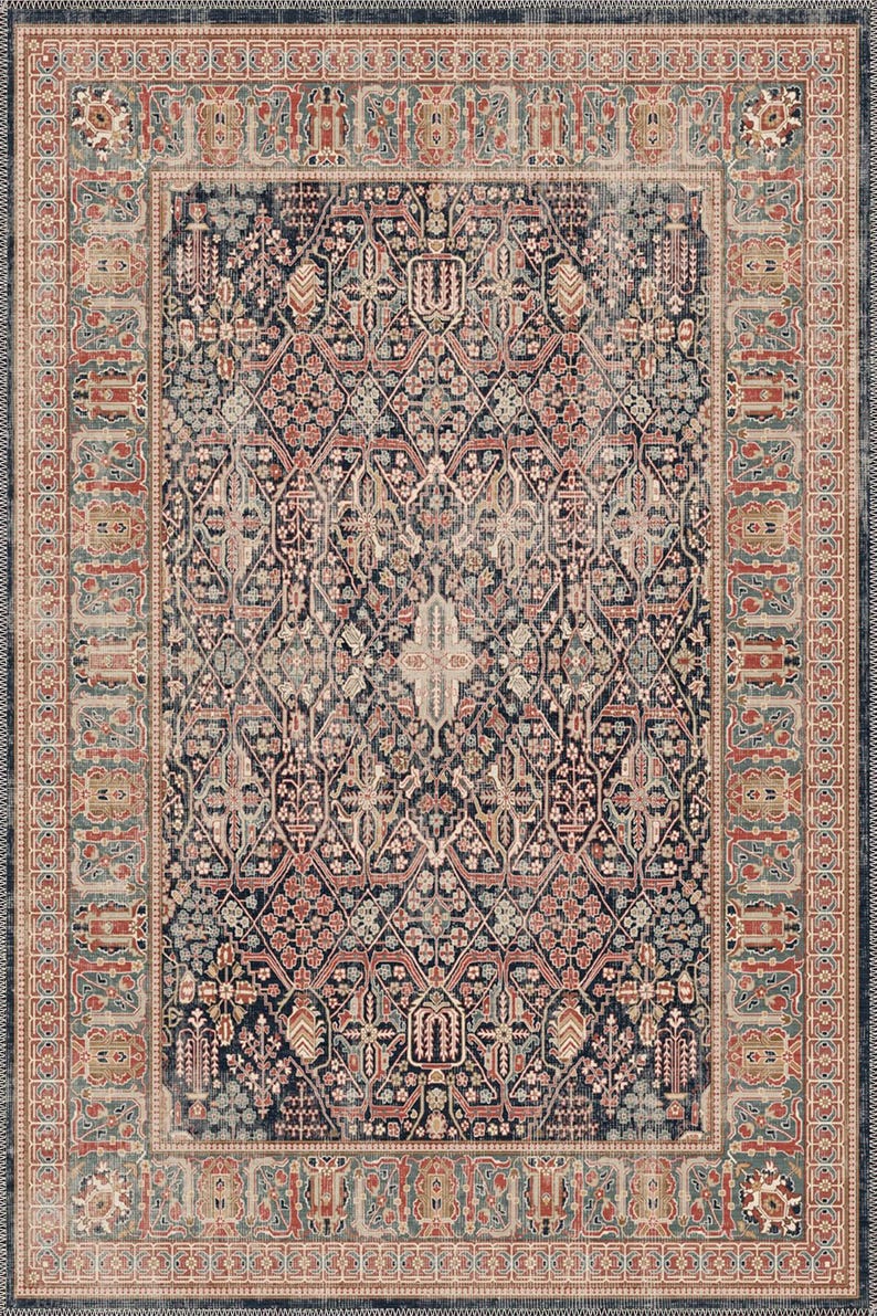 May include: A rectangular area rug with an intricate, traditional design. The rug features a dark navy blue central field with a repeating floral and geometric pattern in shades of red, beige, and teal. A detailed border frames the design.
