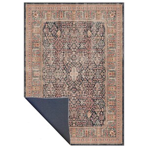 May include: A rectangular area rug with an ornate, traditional design. The rug features a dark navy blue central field with a complex floral pattern in shades of red, beige, and teal. A border in similar colors frames the design.