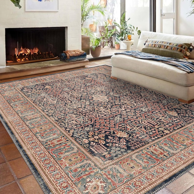May include: A large, rectangular area rug with an intricate, traditional design. The rug features a dark blue central field with a repeating floral pattern in shades of red, beige, and green. A detailed border frames the design, adding to its classic appeal.