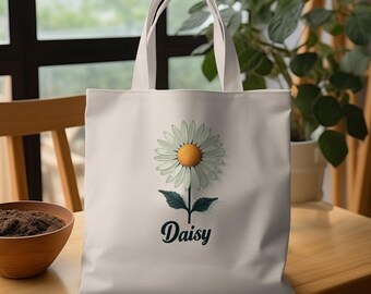 May include: White canvas tote bag with a daisy flower graphic and the word "Daisy" printed in black cursive lettering.