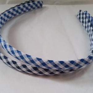 May include: Two fabric-covered headbands, one blue and white gingham and one black and white gingham.