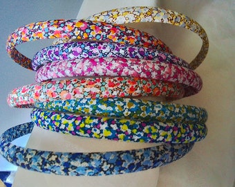 May include: A stack of colorful headbands with a floral pattern. The headbands are made of a soft, flexible material and are perfect for adding a touch of style to any outfit.