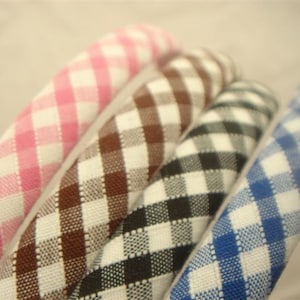 May include: Four gingham hair bands in pink, brown, black, and blue.