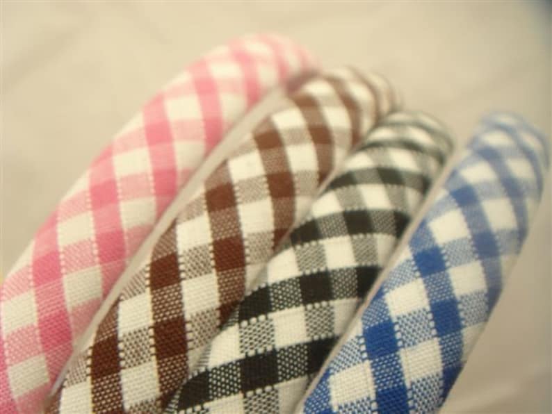 May include: Four gingham hair bands in pink, brown, black, and blue.