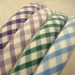 May include: Four gingham fabric headbands in different colors: purple, lavender, green, and blue.