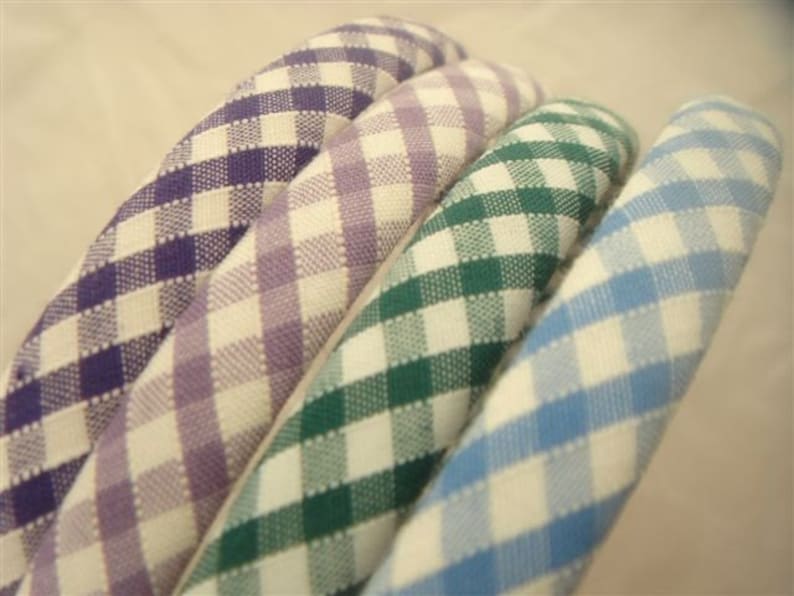 May include: Four gingham fabric headbands in different colors: purple, lavender, green, and blue.