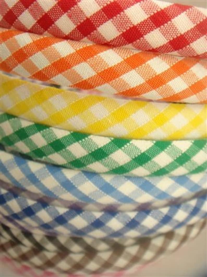 May include: A stack of colorful gingham fabric headbands in red, orange, yellow, green, blue, and brown.