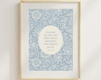 Puede incluir: Una impresión enmarcada con un fondo floral azul claro. Un óvalo en el centro contiene el texto "Come unto me, all ye that labour and are heavy laden, and I will give you rest." El marco es de madera clara.