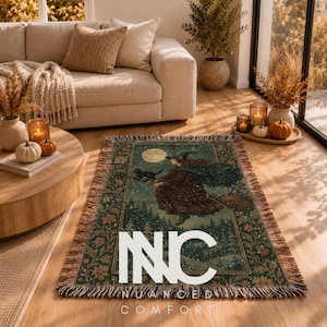 May include: A rectangular woven throw blanket featuring a dark green and brown illustration of a witch flying on a broomstick with a black cat under a full moon, surrounded by a floral border and finished with fringed edges on all sides.