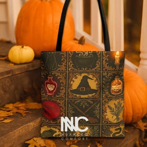 May include: A black tote bag with a witchy design featuring a witch's hat, potion bottles, and a cauldron. The bag has black handles and the text "INC Nuanced Comfort" at the bottom. Pumpkins are in the background.