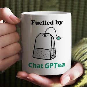 Taza GPTea con la frase "Impulsada por el chat": Taza de cerámica divertida, humor tecnológico, regalo ideal para amigo invisible.
