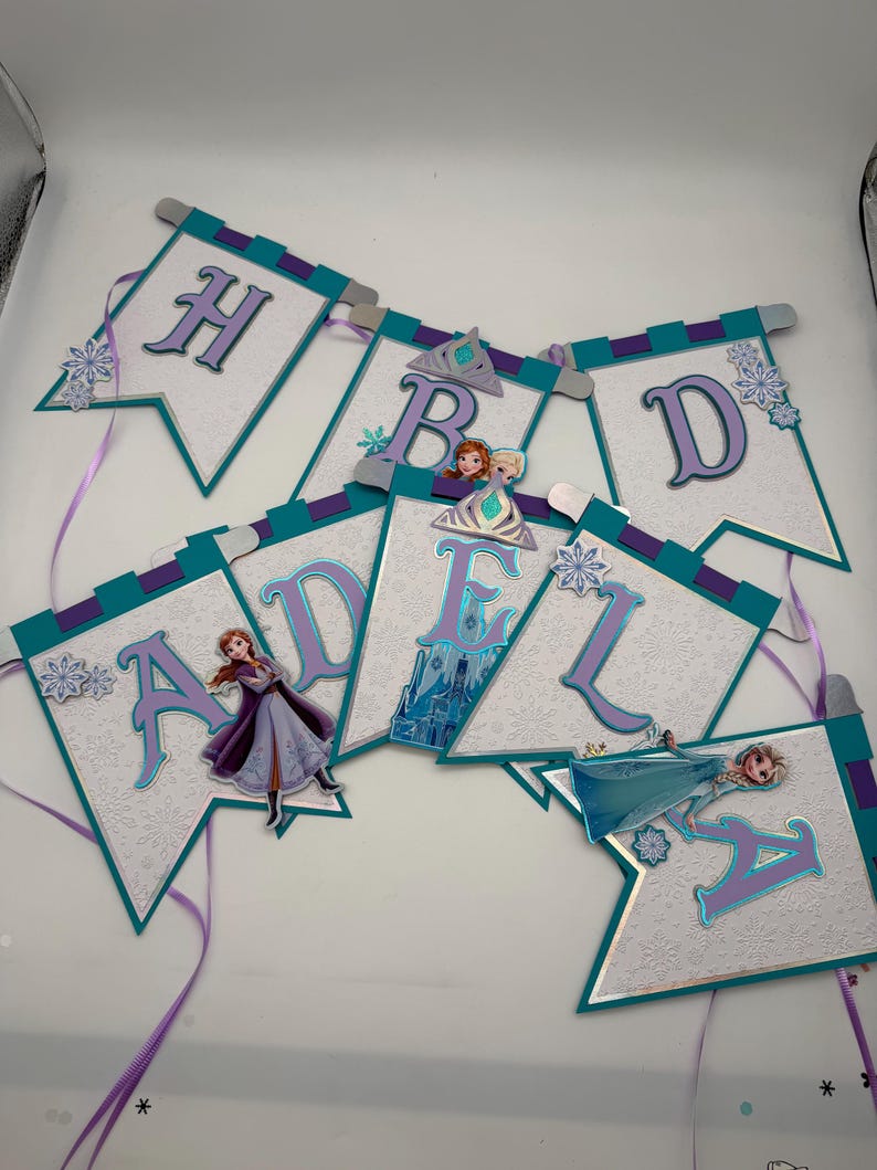 May include: A white ceramic mug with a black handle and the text "But First, Coffee" in a black, handwritten-style font. The mug is on a white surface.