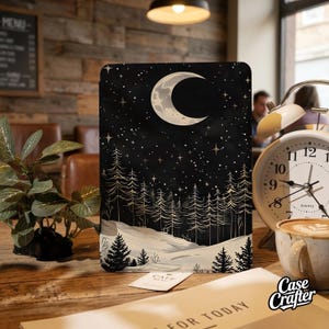 May include: A black case featuring a celestial design with a crescent moon, stars, and a forest silhouette. The case has a wintery landscape with snow and trees. The Case Crafter logo is visible.