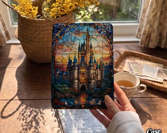 May include: A rectangular e-reader cover featuring a vibrant stained glass style illustration of a castle with blue turrets, stone walls, and a sunset sky. The design includes intricate leaded glass patterns in shades of blue, orange, and yellow.
