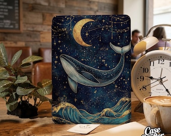 May include: A navy blue tablet case featuring a whale swimming in a starry night sky with a gold crescent moon. Gold waves and stars accent the design. The case has the words "Case Crafter" on the bottom right.