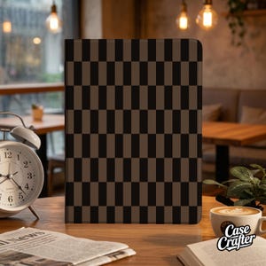 May include: A rectangular case with a brown and black checkered pattern. The case is on a wooden table with a cup of coffee, a clock, and a newspaper. The text "Case Crafter" is on the coffee cup.
