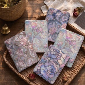 May include: Four rectangular tablet cases featuring a stained glass-inspired design with iridescent pastel roses, swirling vines, and leaves in shades of soft pink, lavender, and blue, arranged in a woven wicker tray.