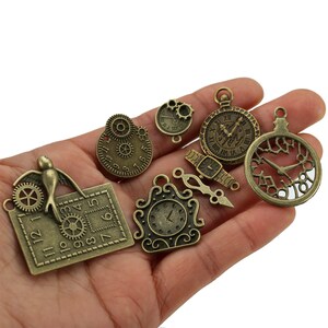 May include: A collection of antique bronze-colored metal charms featuring various clock and watch designs. The set includes a rectangular clock with a bird, several round clock faces with gears, a small wristwatch, and a decorative clock pendant.