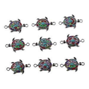 May include: Nine silver-toned metal turtle charms arranged in a grid. Each turtle features a central teardrop-shaped turquoise-colored stone surrounded by a ring of small, multi-colored rhinestones. Each charm has two small loops on the sides.