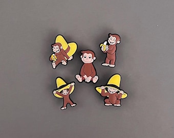 Dijes de zuecos de mono curioso - Dijes de zapatos de sombrero amarillo de Banana George - Accesorios de regalo para niños pequeños con dibujos animados de aventuras - Juego disponible