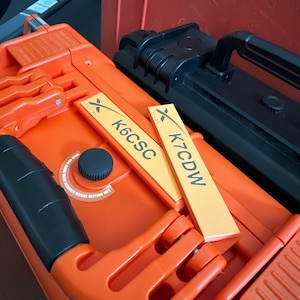 May include: Two orange and black hard cases with labels that read "K7CDW" and "K6CSC".
