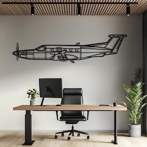 Könnte beinhalten: Ein schwarzes Wandkunstobjekt aus Metall in Form eines einmotorigen Turboprop-Flugzeugs im Profil. Das Design zeigt eine detaillierte Kontur des Rumpfes, der Tragflächen, des Leitwerks und eines Frontpropellers, horizontal an einer weißen Wand.