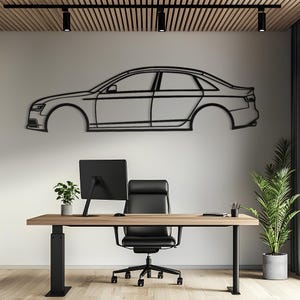 May include: A black metal wall art piece featuring the minimalist outline of a sedan car in profile. The design captures the side view of the vehicle, including the roofline, windows, door panels, and trunk, rendered as a continuous thin frame.