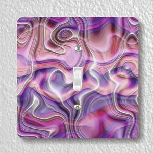 May include: Purple and pink abstract swirl light switch cover. The design resembles a marble or agate stone.