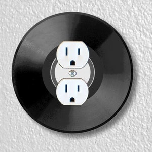 May include: A black vinyl record with two white electrical outlets on it.