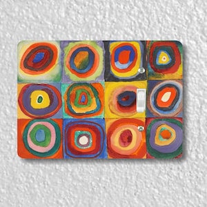 May include: A light switch cover featuring a colorful abstract painting with concentric circles in various shades of red, yellow, blue, green, and purple.