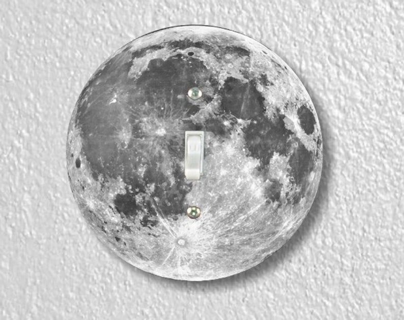 May include: A round light switch cover with a black and white image of the moon.