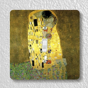 May include: A light switch cover featuring a reproduction of Gustav Klimt's painting "The Kiss". The painting depicts a couple embracing in a golden, mosaic-like style.