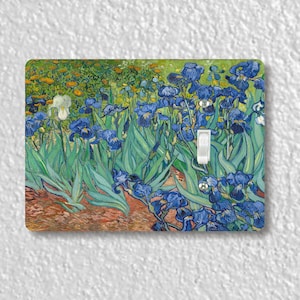 May include: A light switch cover featuring a painting of blue irises with green leaves and a yellow background. The painting is reminiscent of the style of Vincent van Gogh.
