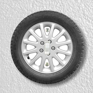 May include: A silver car wheel with a light switch in the center. The wheel is mounted on a white wall.