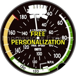 May include: A black and white airspeed indicator gauge with a yellow and green arc. The gauge reads "FREE PERSONALIZATION" in white text.