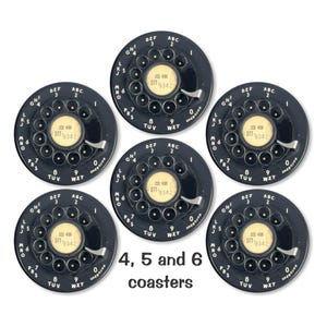 May include: Six black coasters with a vintage rotary phone dial design. Each coaster features a white dial with black numbers and letters. The coasters are labeled with the numbers 4, 5, and 6.