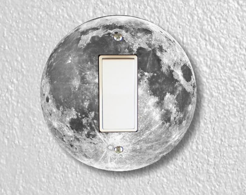 May include: A round light switch cover with a black and white image of the moon.