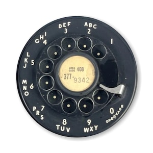 May include: A black rotary dial phone with a white dial face. The dial face has the numbers 0-9 and letters ABC, DEF, GHI, JKL, MNO, PRS, TUV, WXY. The area code 408 and phone number 377-9342 are printed on the dial face.