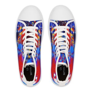 May include: A pair of white canvas high-top trainers with a colourful abstract design. The design features red, blue and yellow colours in a swirling pattern. The trainers have white laces and a black insole with the text "US M17F19".