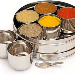 Scatola di spezie indiane con coperchio trasparente. 7 inserti con 6 spezie, incluso un cucchiaio e una scheda di ricette per iniziare. Ottima idea regalo