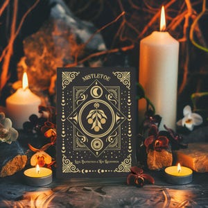 Luxurious black Yule card featuring golden mistletoe design, moon phases, and stars. "Mistletoe" and "For Protection & New Beginnings" in ornate gold text.